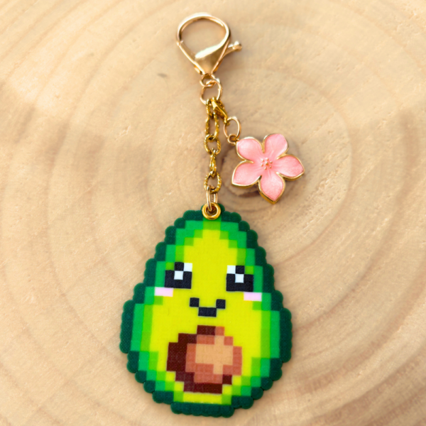 Porte-clé et bijou de sac soré Pixel art en perles thermocollés Avoki l'avocat avec sa fleur de cerisier.