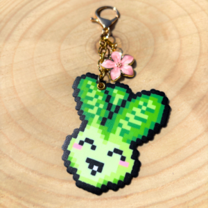 Porte-clé doré en Pixel art Pakou le pak choi en perles thermocollantes avec sa fleur de cerisier rose.